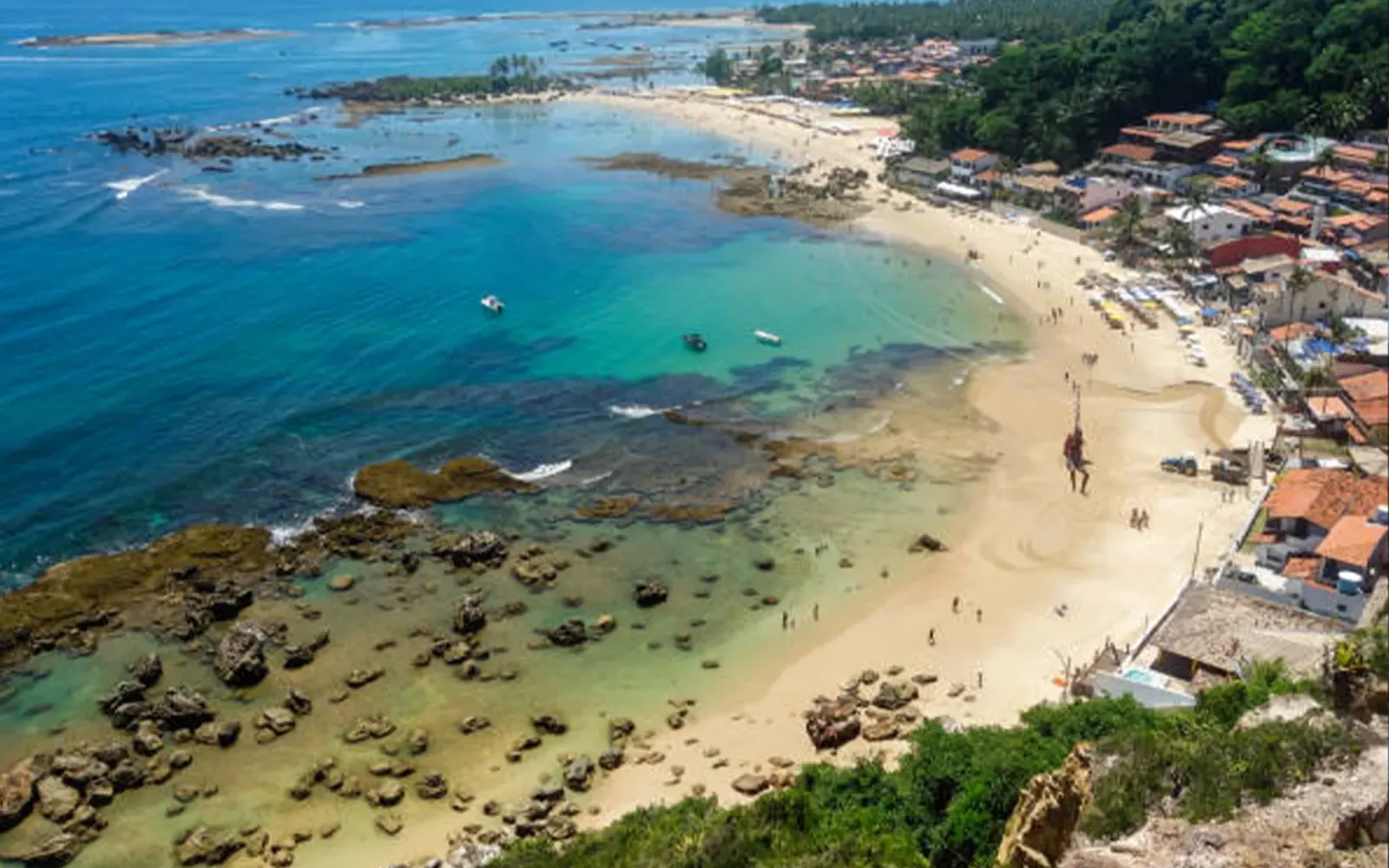 Mar transparente e praia em Morro de São Paulo em dia de sol